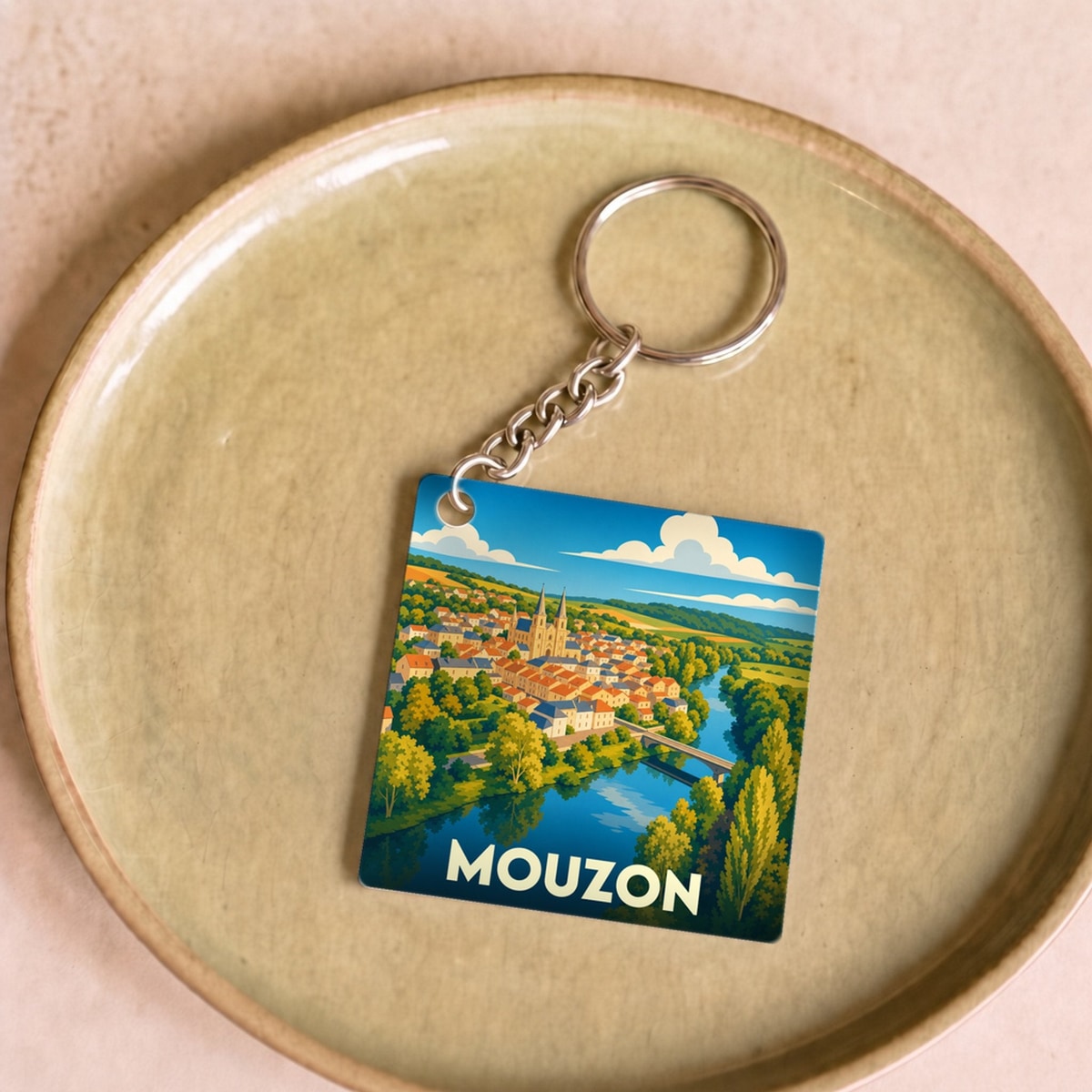 Porte-clés souvenir de la ville de Mouzon avec une illustration stylisée et colorée.