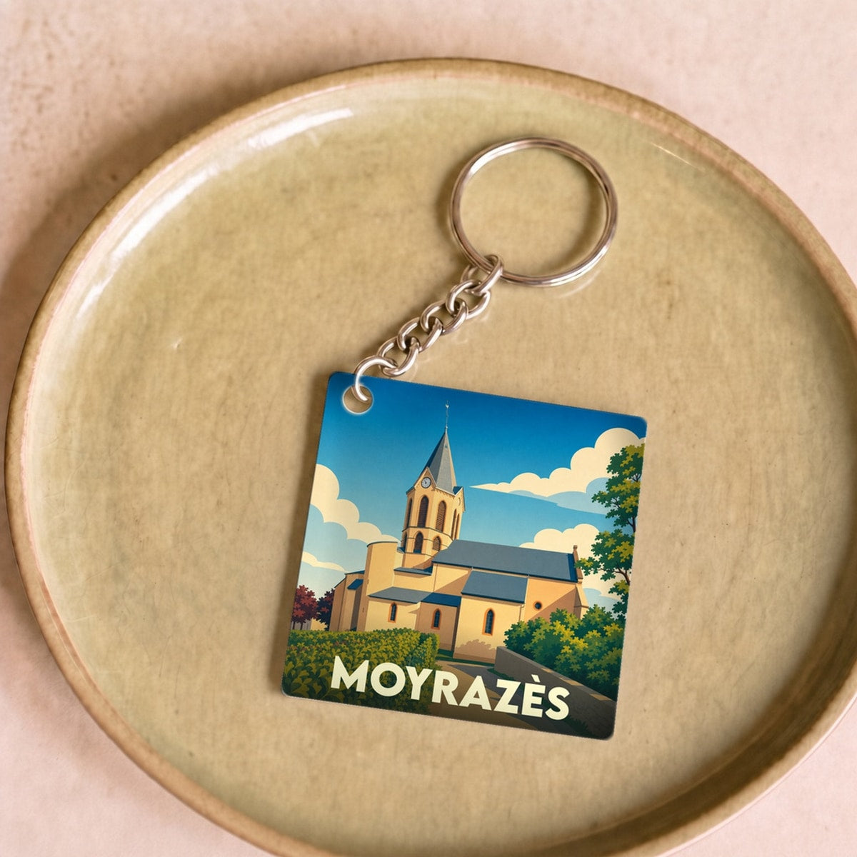 Porte-clés souvenir de la ville de Moyrazès avec une illustration stylisée de son église.