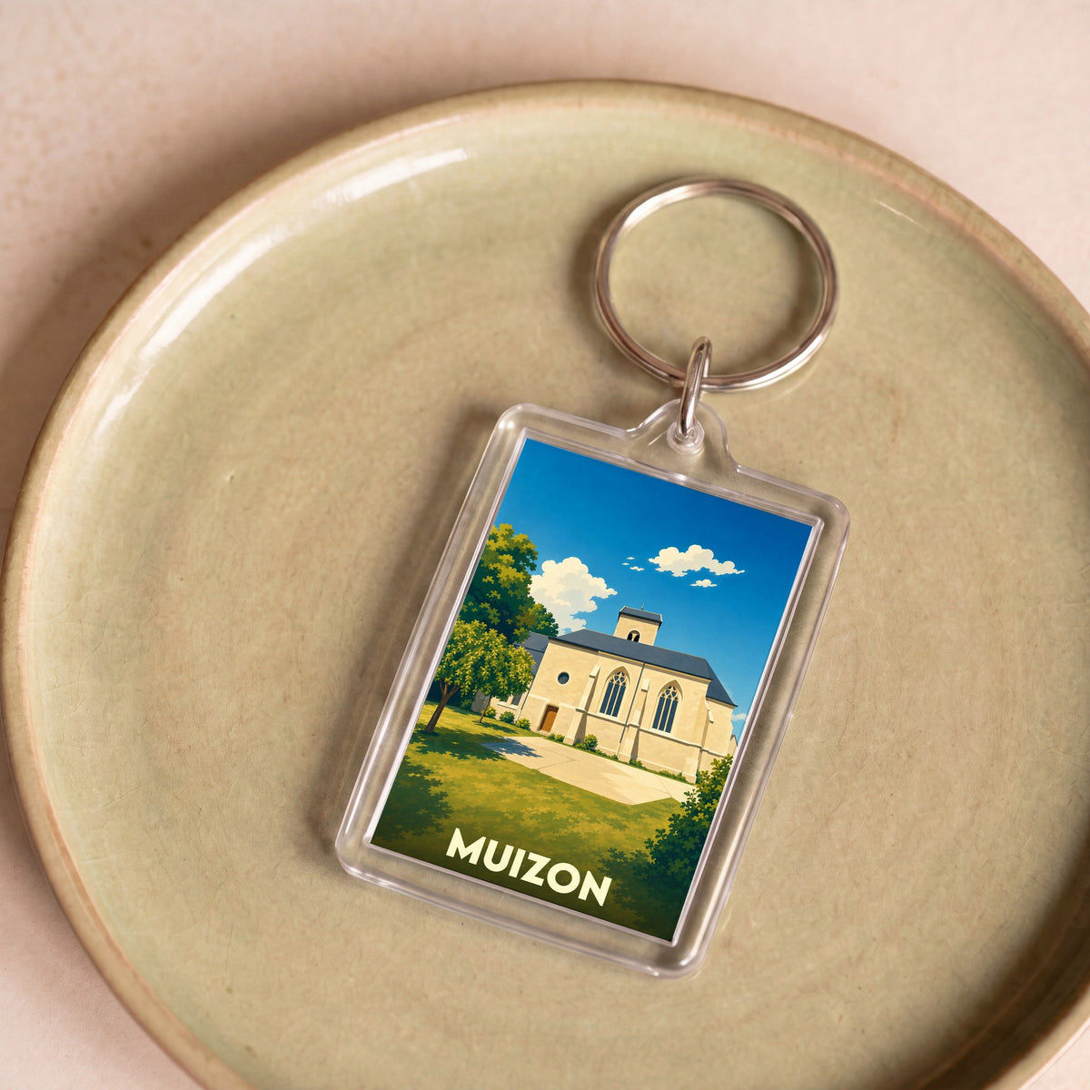 Porte-clés souvenir de la ville de Muizon avec une illustration stylisée de son église.