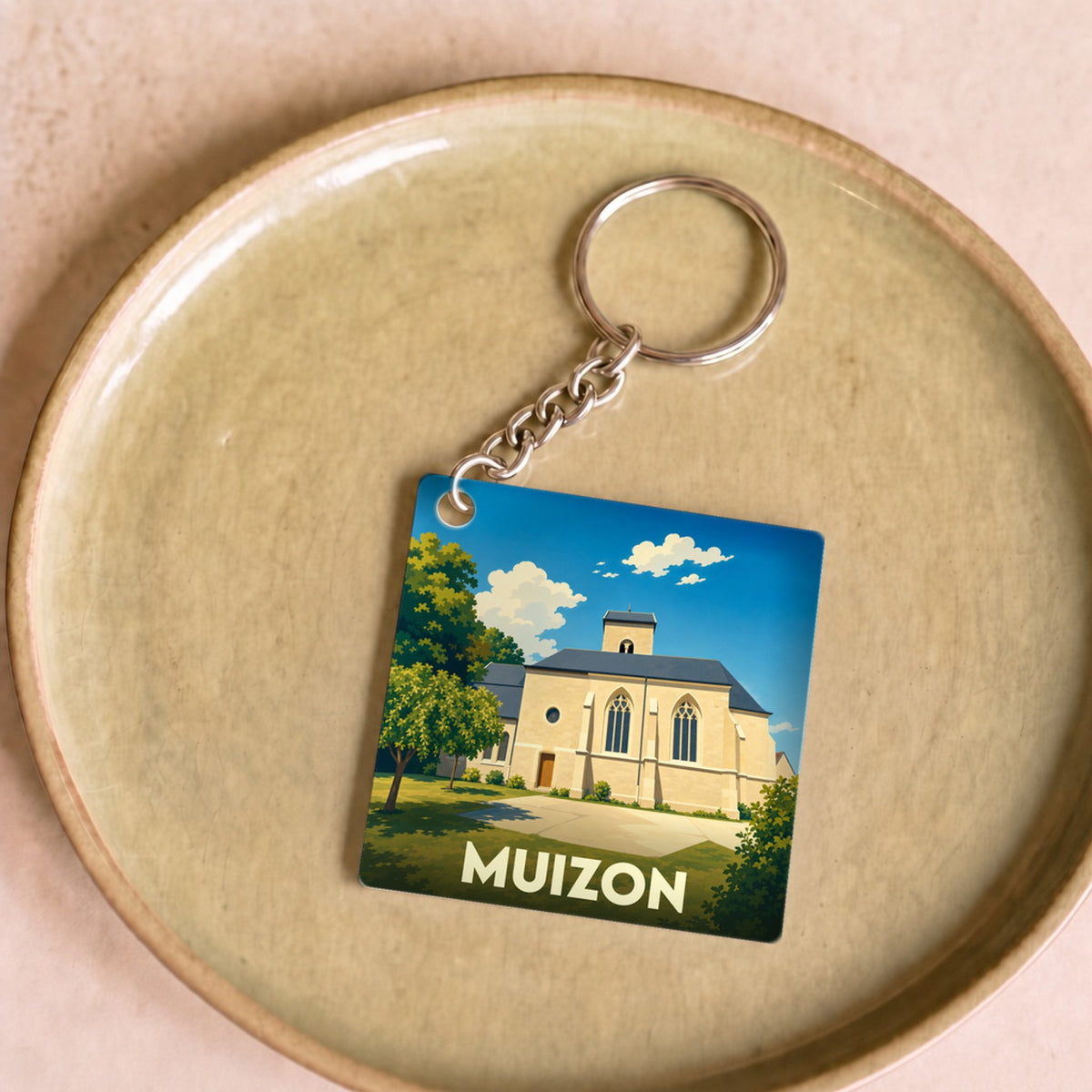 Porte-clés souvenir de la ville de Muizon avec une illustration stylisée de son église.
