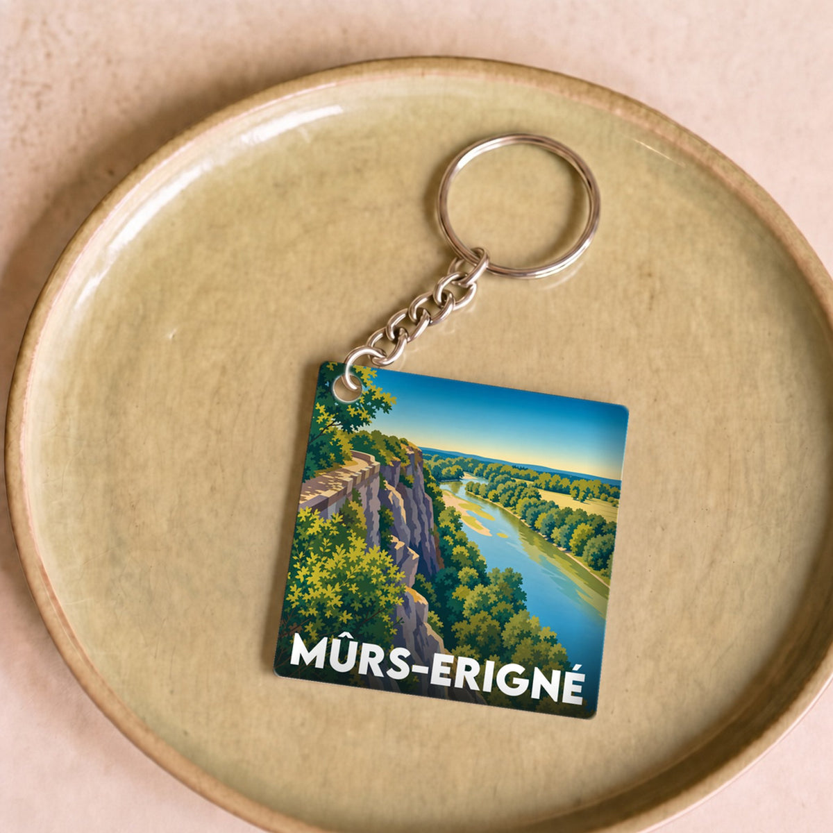 Porte-clés souvenir de la ville de Mûrs-Erigné avec une illustration stylisée de ses paysages naturels.
