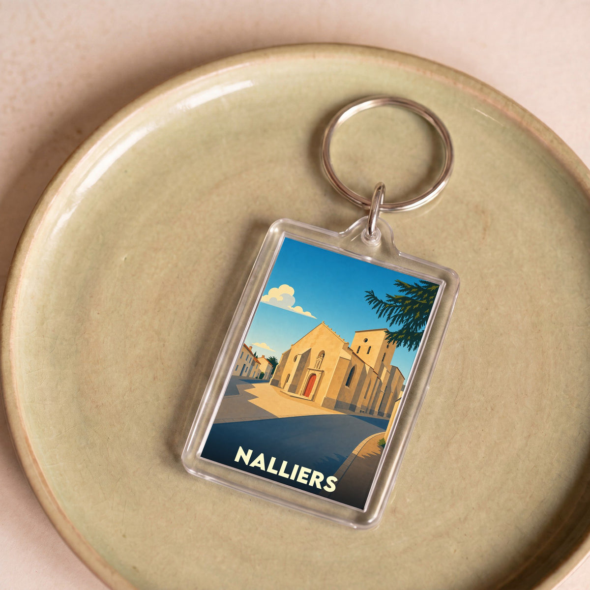 Porte-clés souvenir de la ville de Nalliers avec une illustration stylisée de son église.