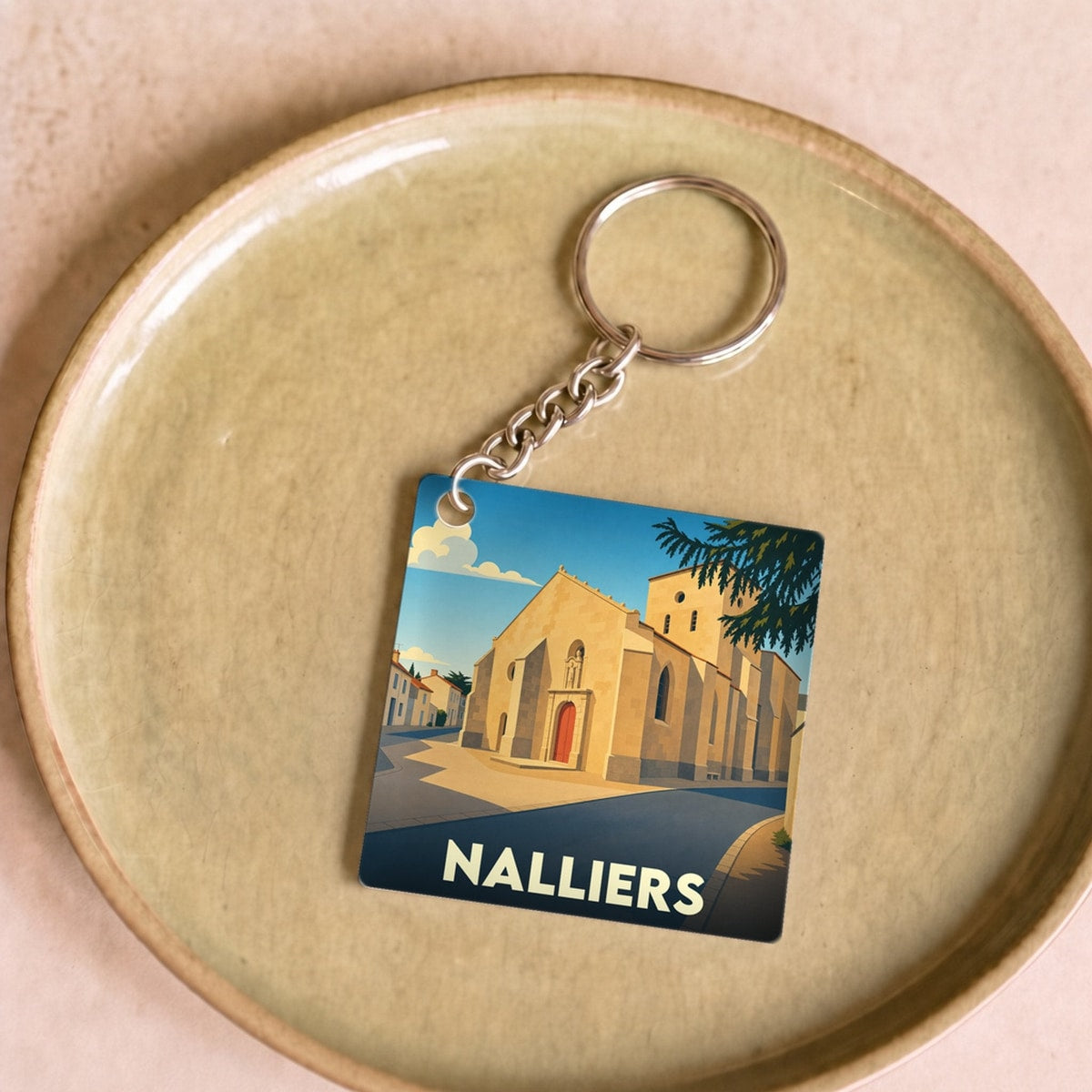 Porte-clés souvenir de la ville de Nalliers avec une illustration stylisée de son église.