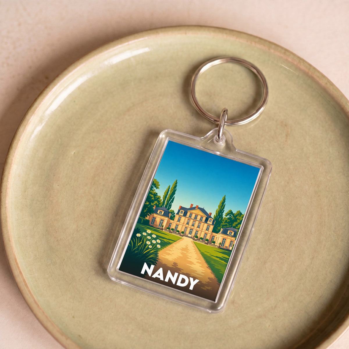 Porte-clés souvenir de la ville de Nandy avec une illustration stylisée de son château.