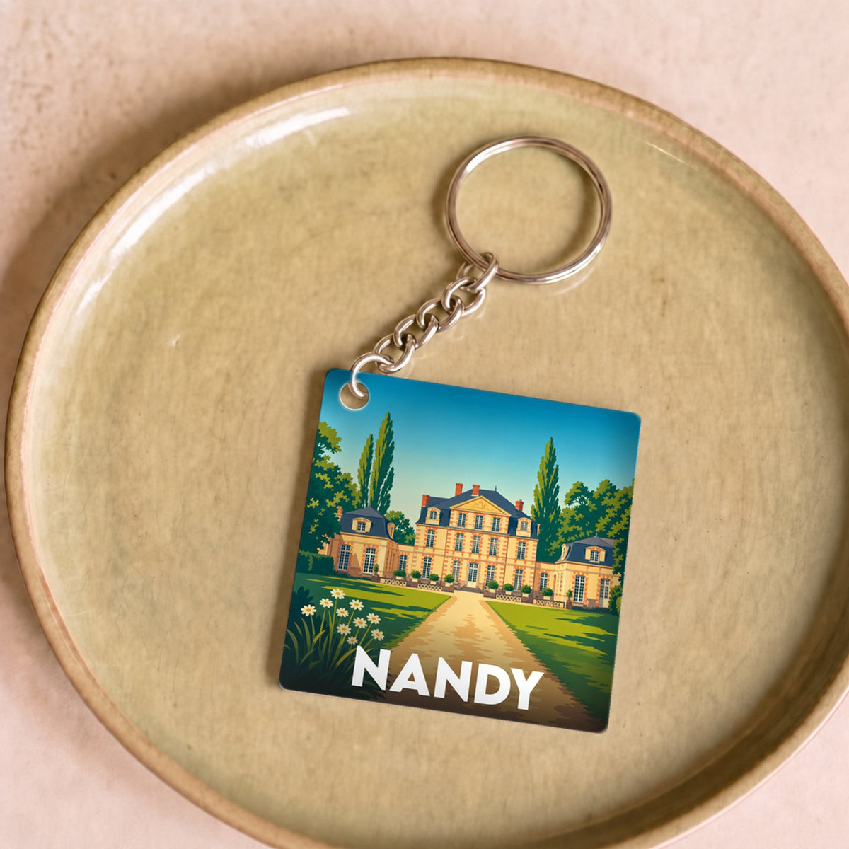 Porte-clés souvenir de la ville de Nandy avec une illustration stylisée de son château.