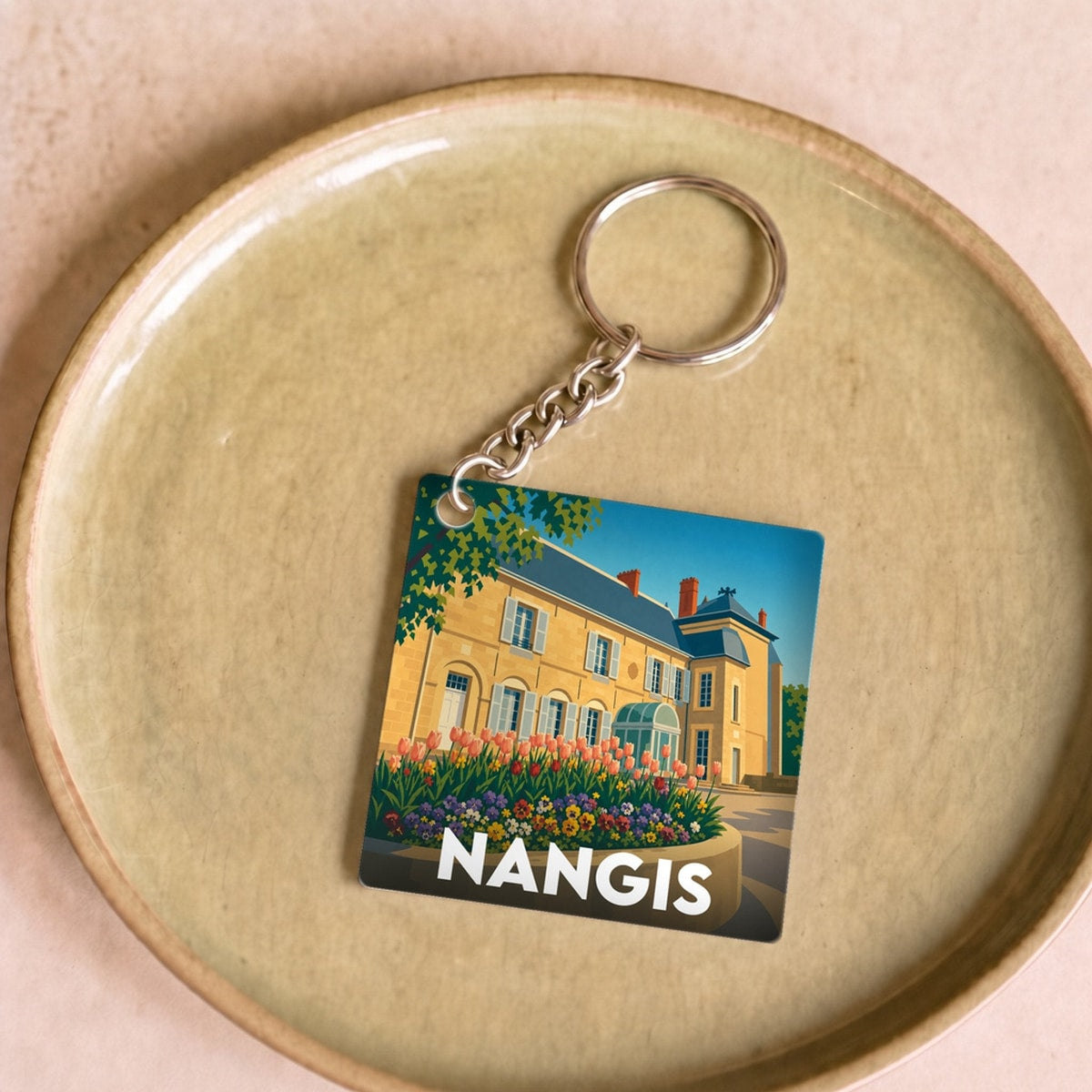 Porte-clés souvenir de la ville de Nangis avec une illustration stylisée.