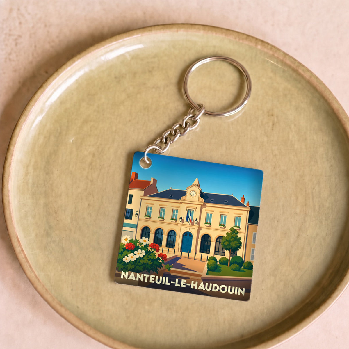 Porte-clés souvenir de la ville de Nanteuil-le-Haudouin avec une illustration stylisée de la mairie.