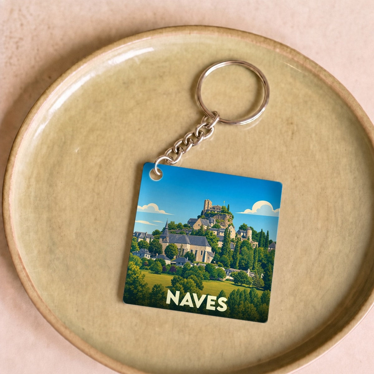 Porte-clés souvenir de la ville de Naves avec une illustration stylisée.