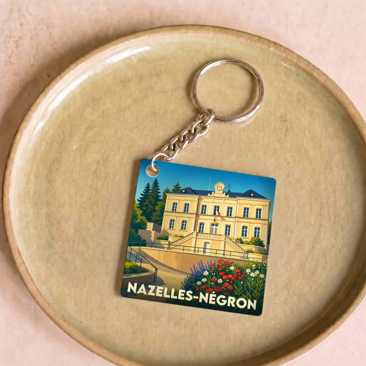 Porte-clés souvenir de la ville de Nazelles-Négron avec une illustration stylisée.