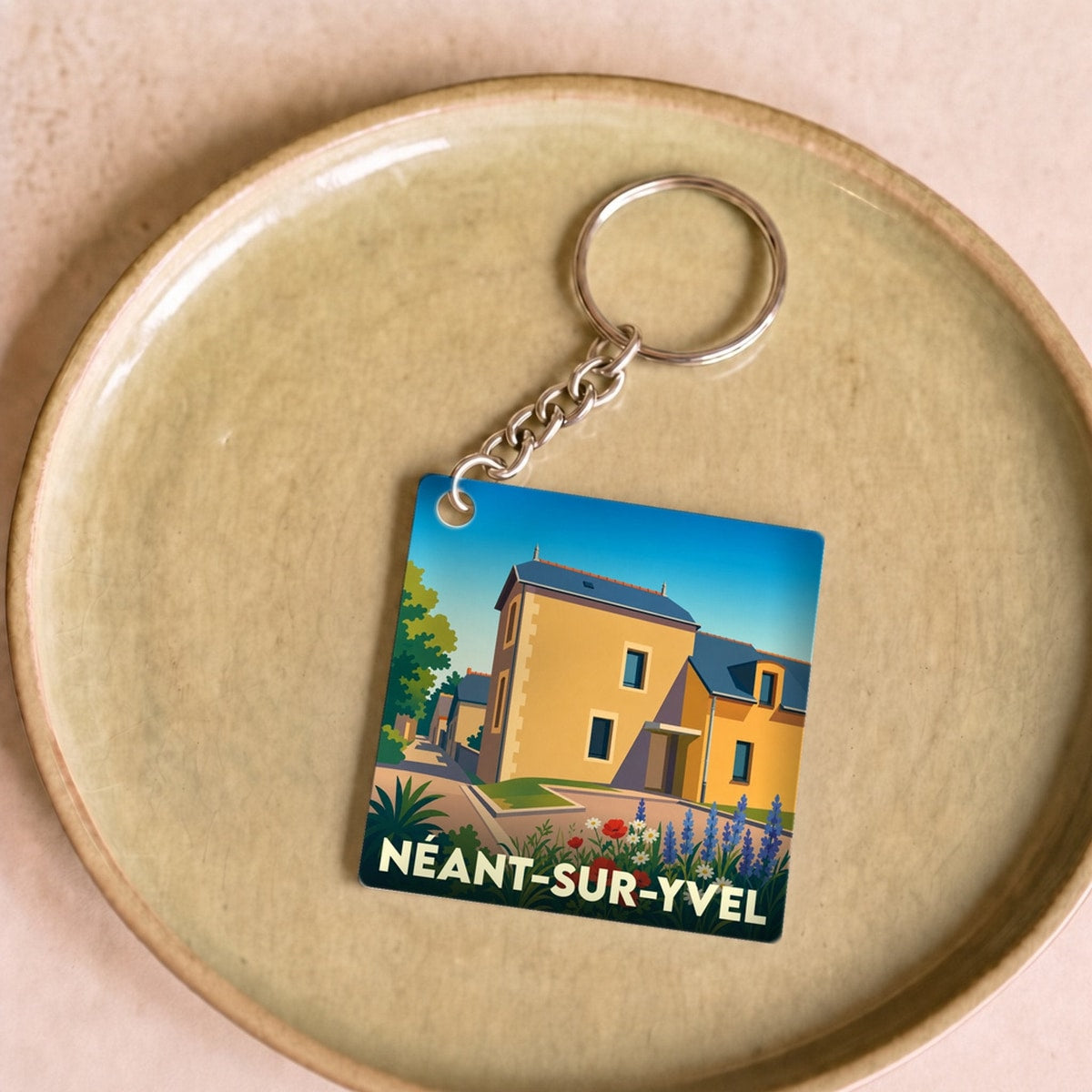 Porte-clés souvenir de la ville de Néant-sur-Yvel avec une illustration stylisée.