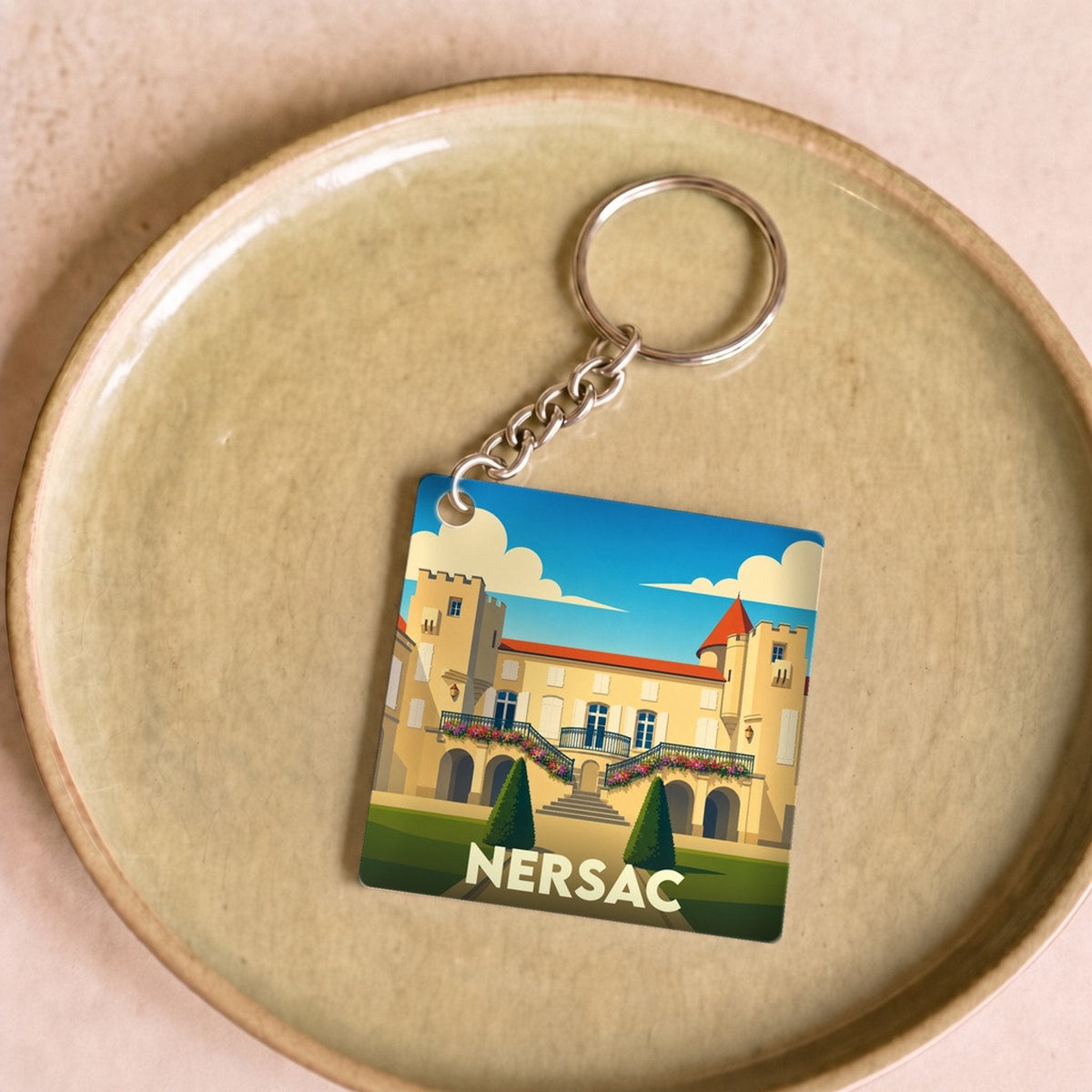 Porte-clés souvenir de la ville de Nersac avec une illustration stylisée de son château.