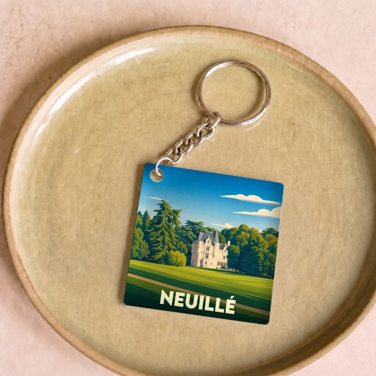 Porte-clés souvenir de la ville de Neuillé avec une illustration stylisée de son château.