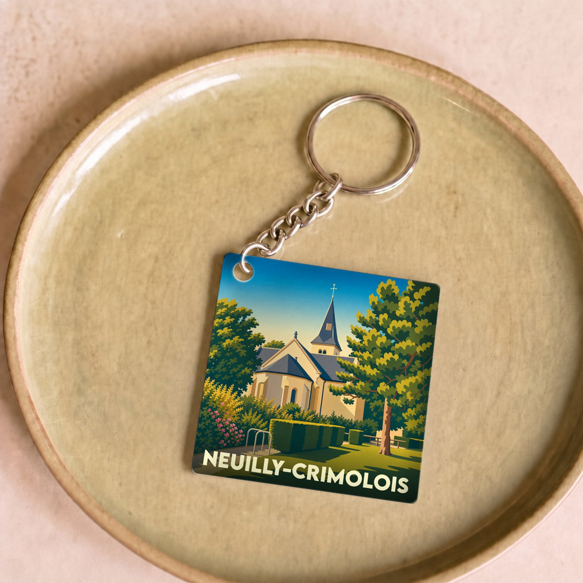 Porte-clés souvenir de la ville de Neuilly-Crimolois avec une illustration stylisée d'une église.