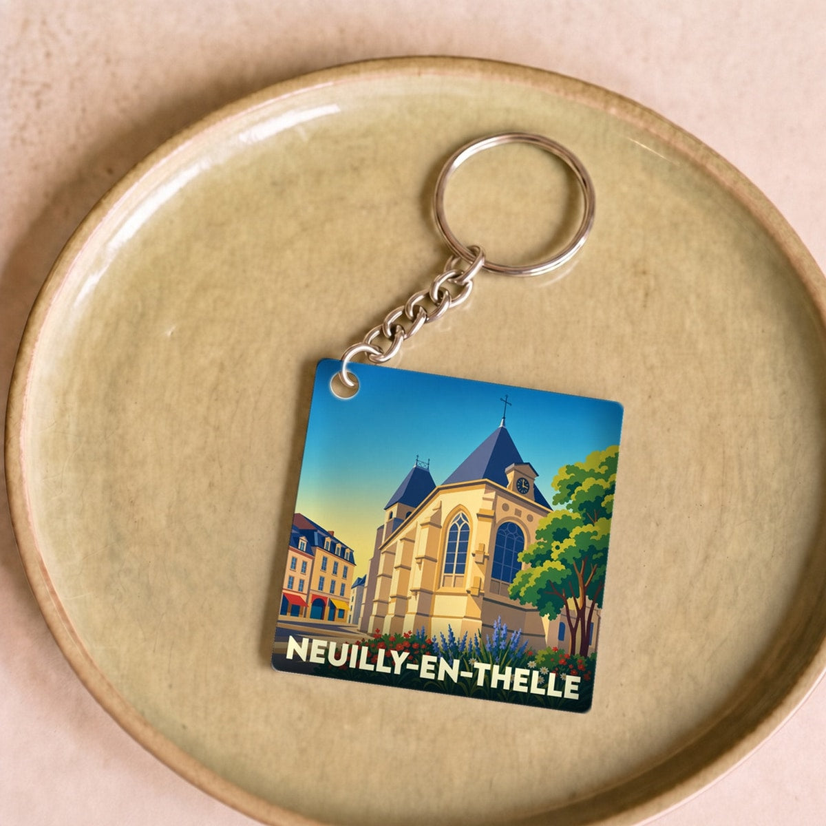 Porte-clés souvenir de la ville de Neuilly-en-Thelle avec une illustration stylisée d'une église.