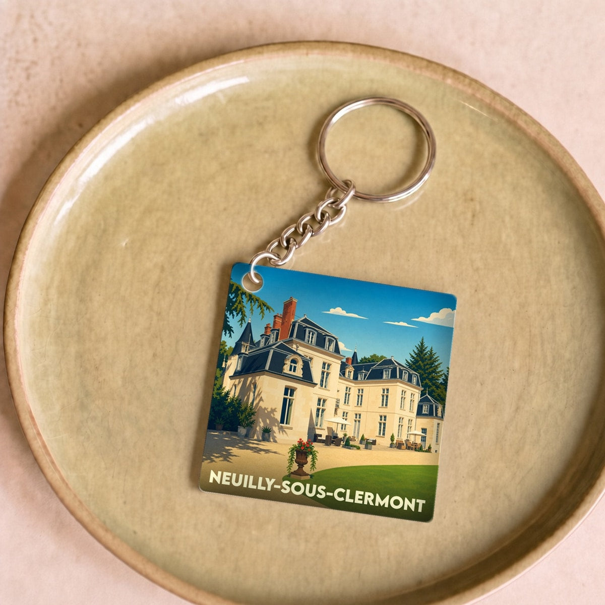 Porte-clés souvenir de la ville de Neuilly-sous-Clermont avec une illustration stylisée d'un château.