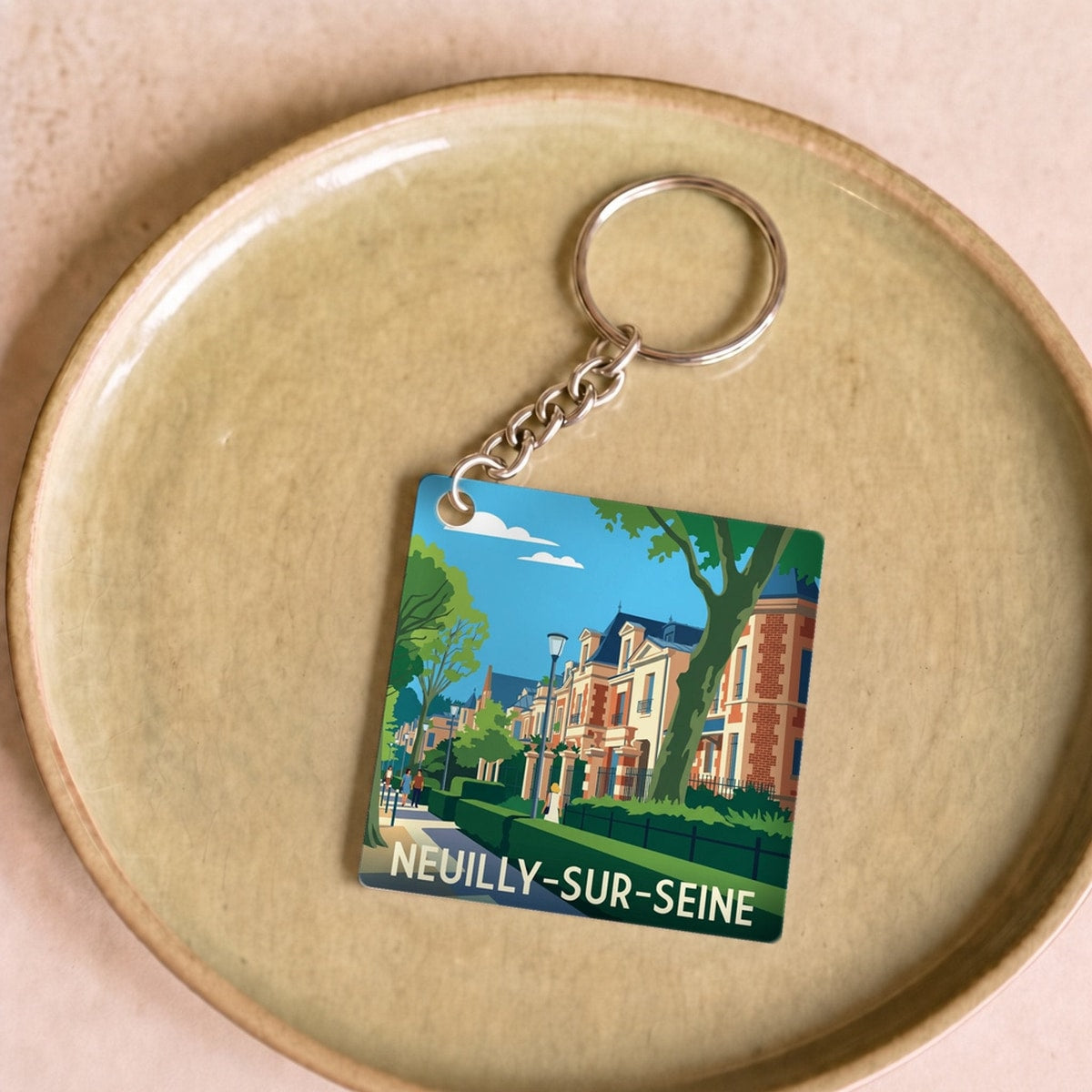 Porte-clés souvenir de la ville de Neuilly-sur-Seine avec une illustration stylisée.