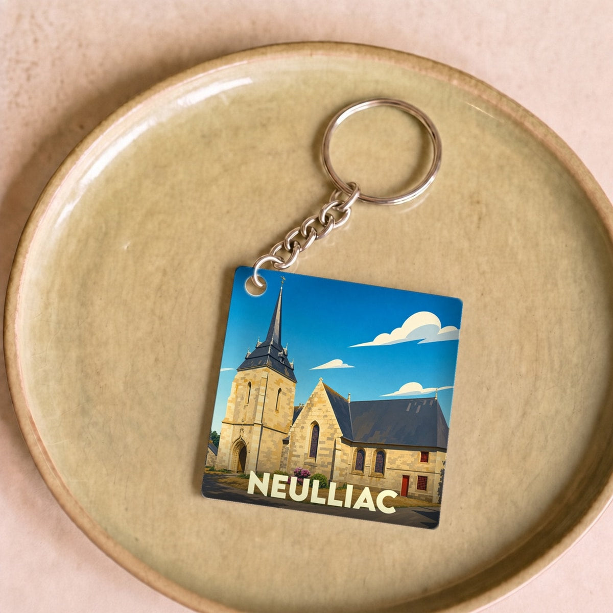 Porte-clés souvenir de la ville de Neulliac avec une illustration stylisée de son église.
