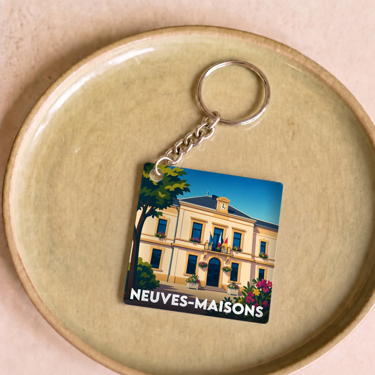 Porte-clés souvenir de la ville de Neuves-Maisons avec une illustration stylisée de sa mairie.