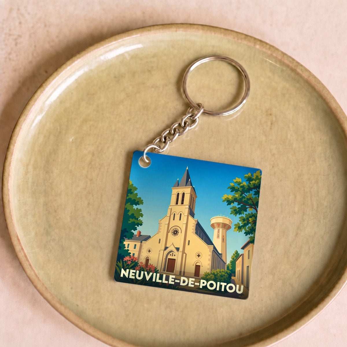 Porte-clés souvenir de la ville de Neuville-de-Poitou avec une illustration stylisée de son église.