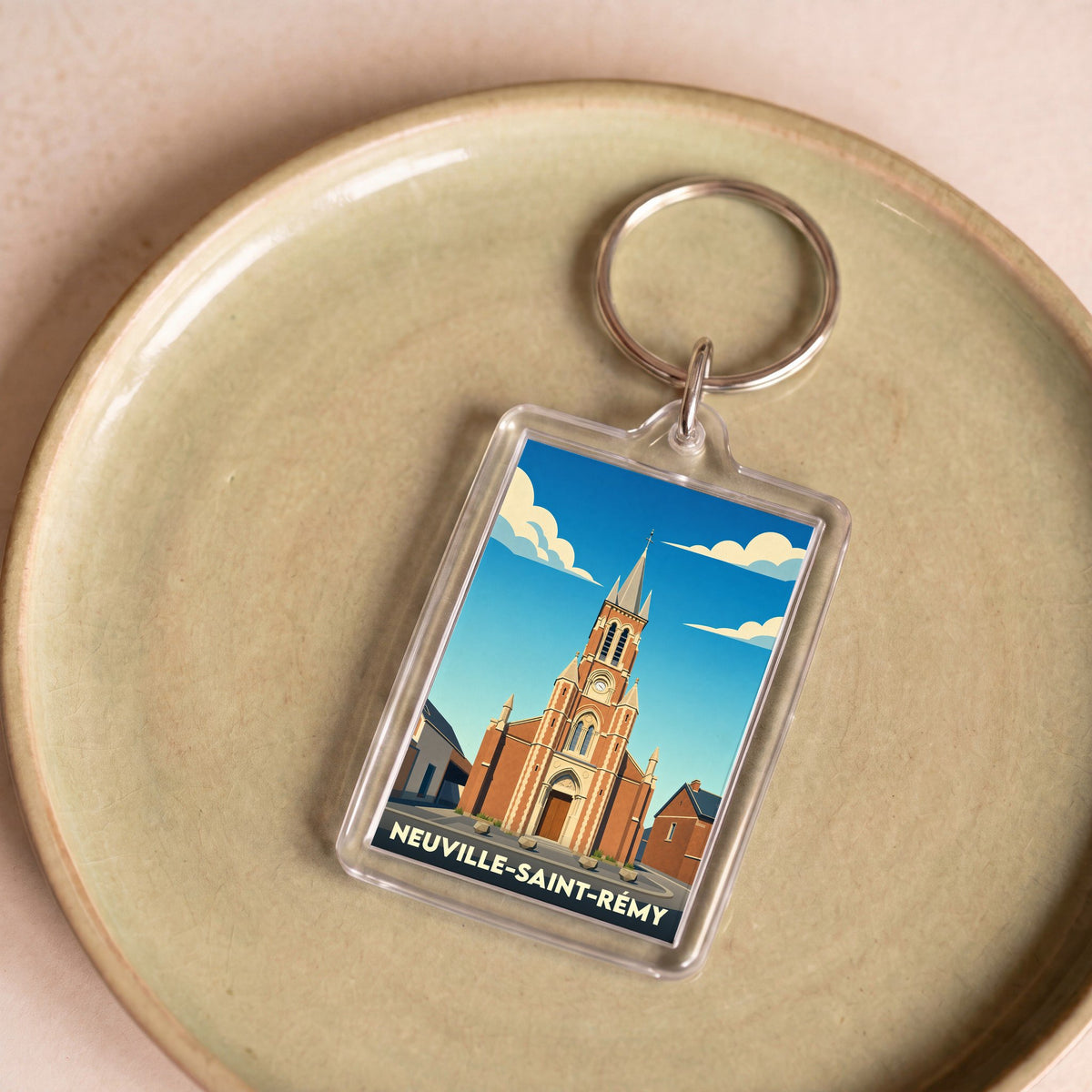 Porte-clés souvenir de la ville de Neuville-Saint-Rémy avec une illustration stylisée de son église.