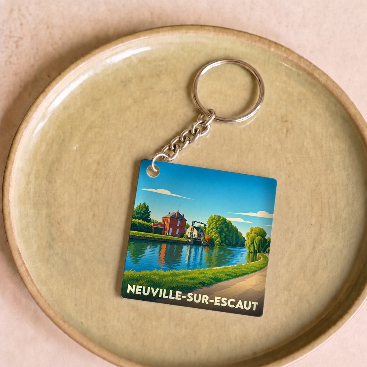 Porte-clés souvenir de la ville de Neuville-sur-Escaut avec une illustration stylisée des bords de l'Escaut.