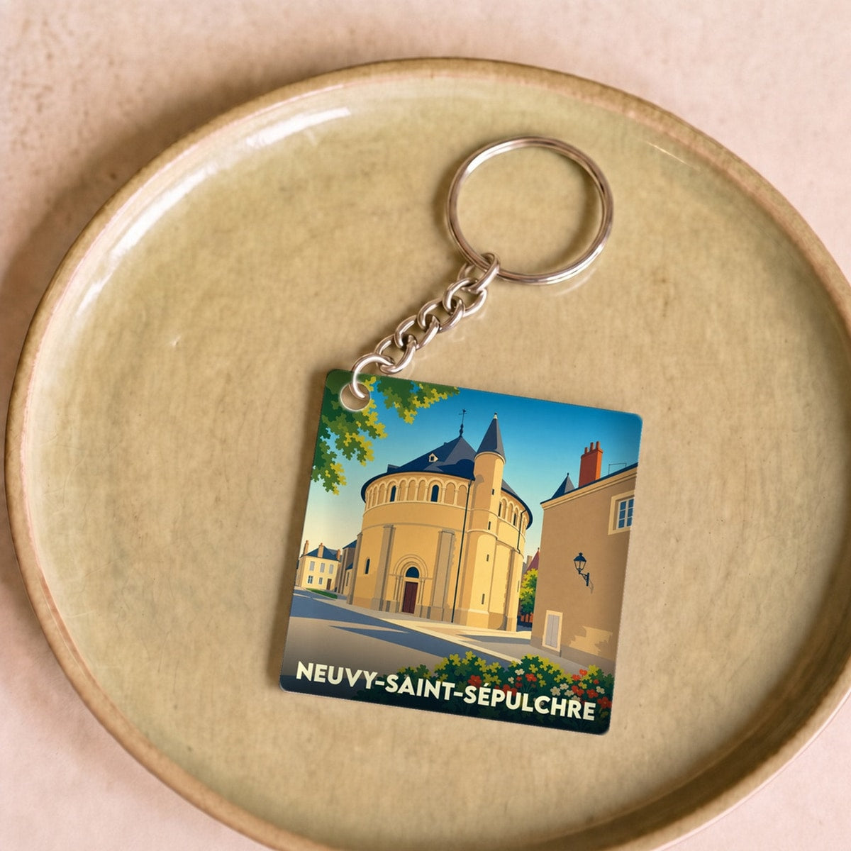 Porte-clés souvenir de la ville de Neuvy-Saint-Sépulchre avec une illustration stylisée.