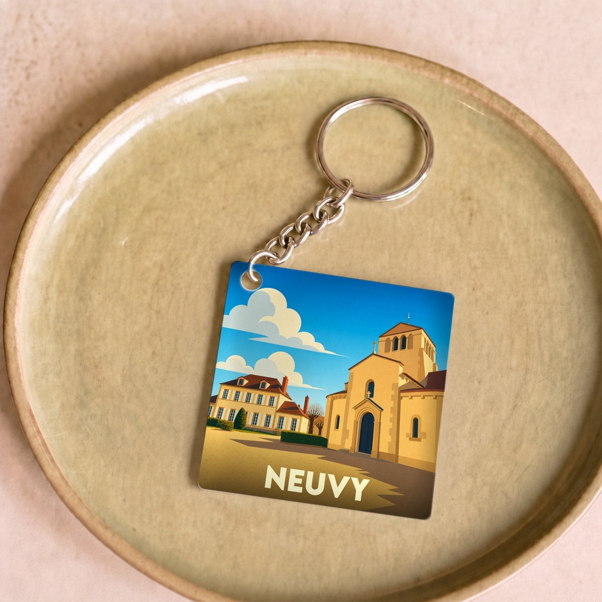 Porte-clés souvenir de la ville de Neuvy avec une illustration stylisée.