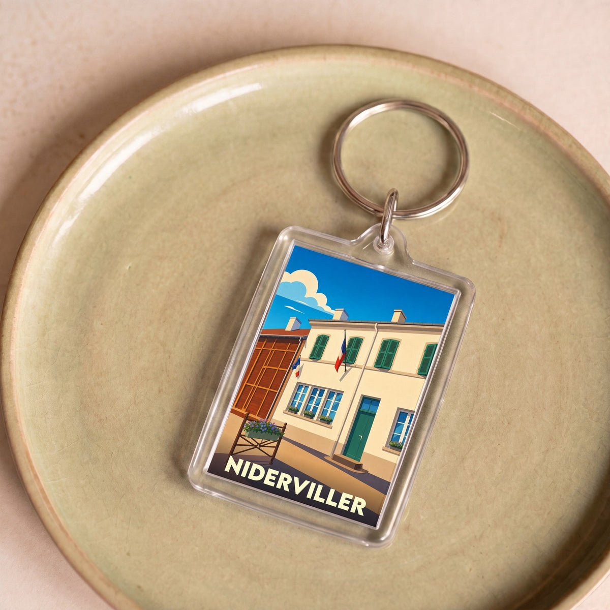 Porte-clés souvenir de la ville de Niderviller avec une illustration stylisée d'un bâtiment typique.