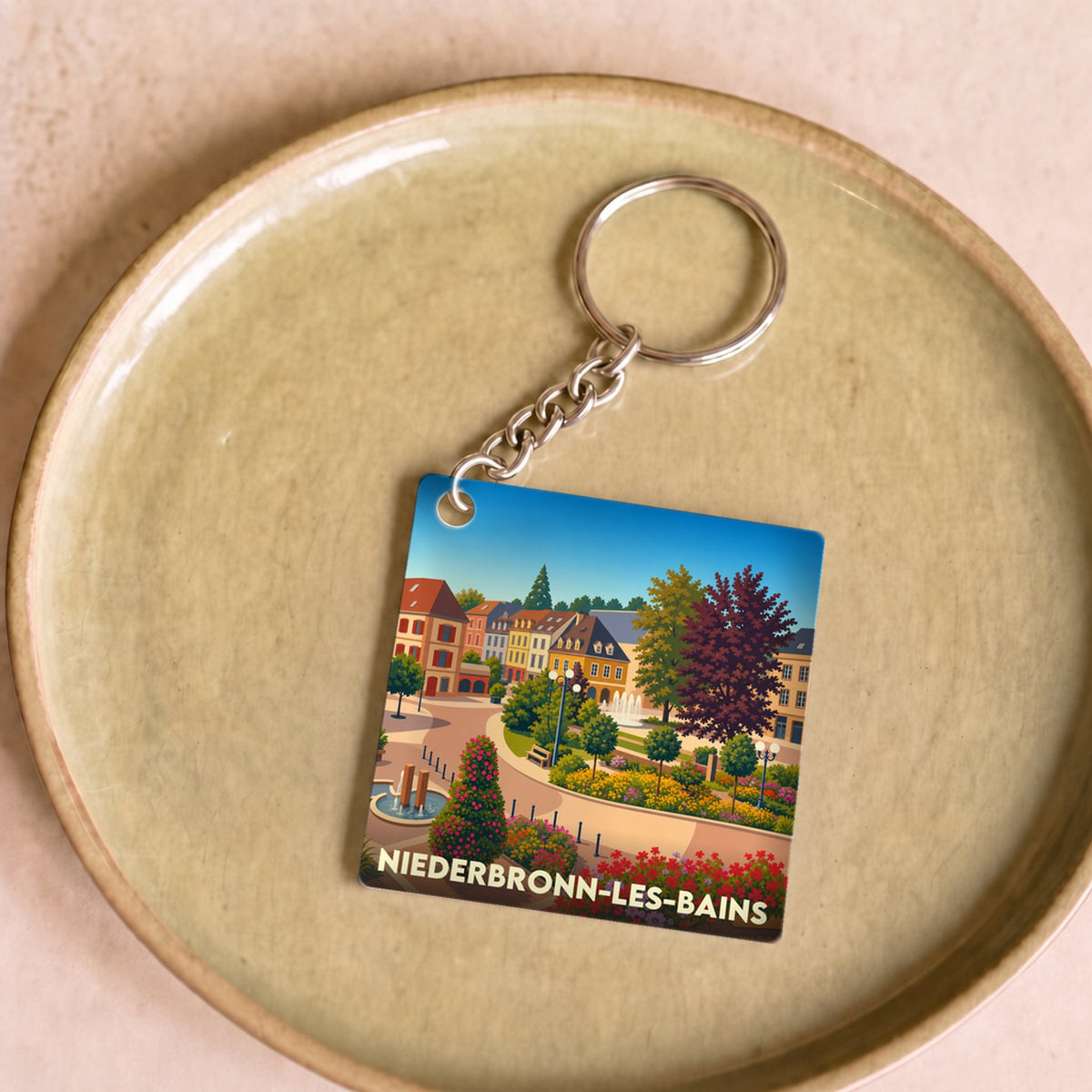 Porte-clés souvenir de la ville de Niederbronn-les-Bains avec une illustration stylisée et colorée.