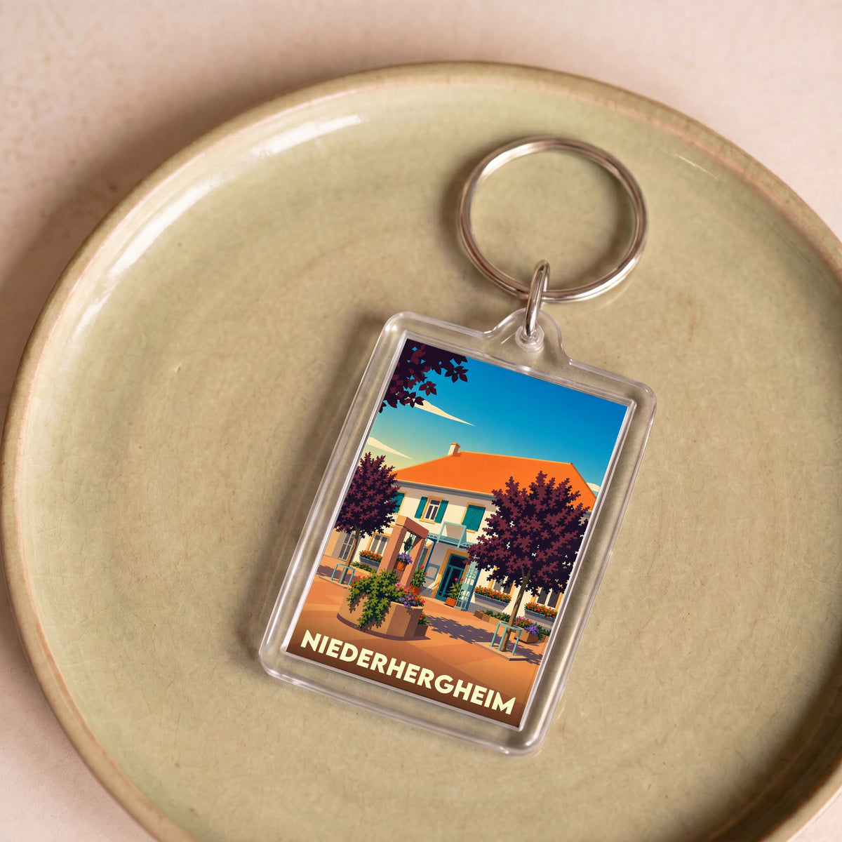 Porte-clés souvenir de la ville de Niederhergheim avec une illustration stylisée.
