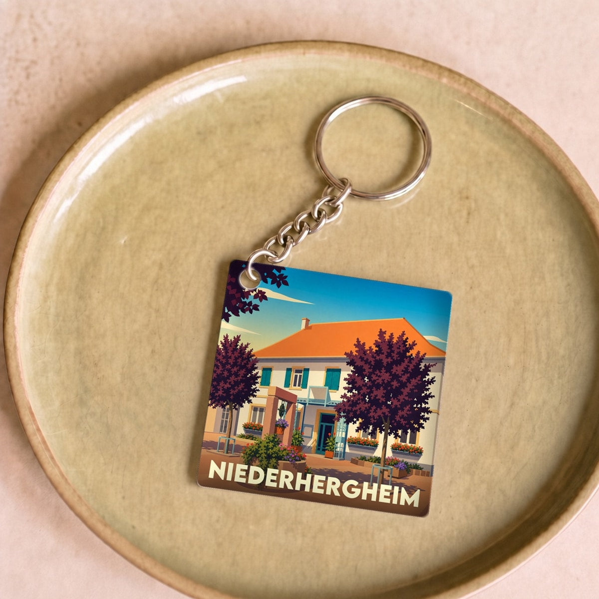 Porte-clés souvenir de la ville de Niederhergheim avec une illustration stylisée.