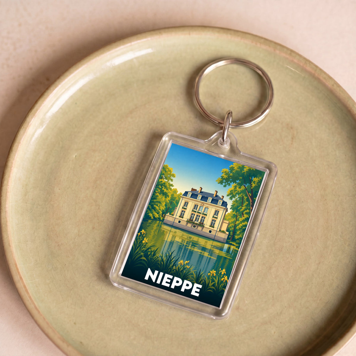 Porte-clés souvenir de la ville de Nieppe avec une illustration stylisée d'un château.