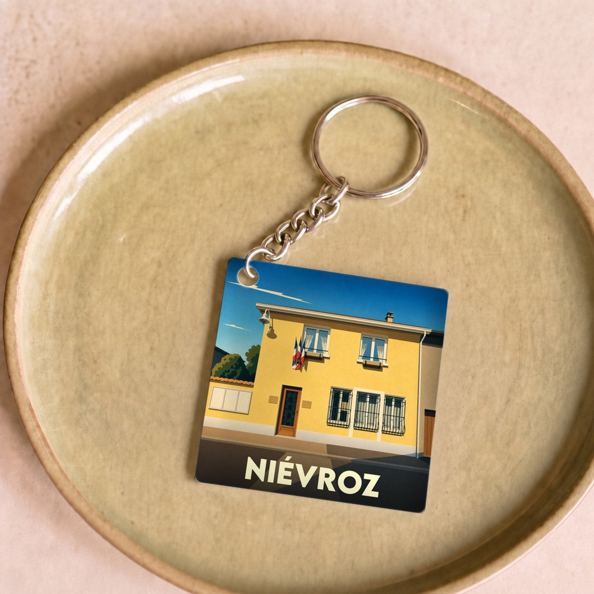 Porte-clés souvenir de la ville de Niévroz avec une illustration stylisée.