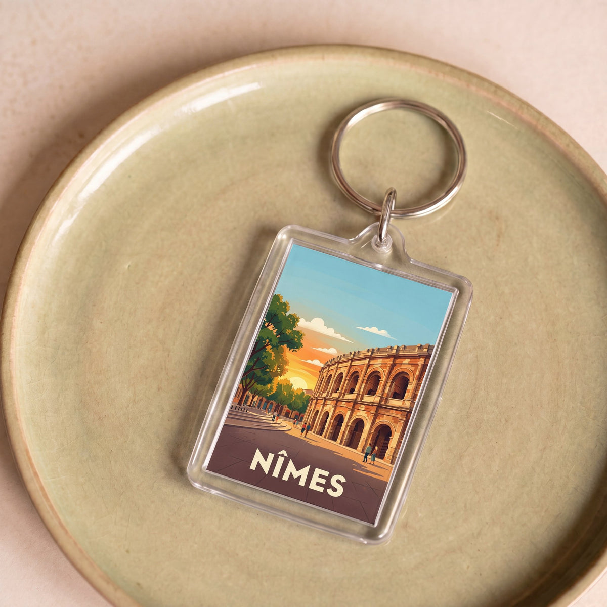 Porte-clés souvenir de la ville de Nîmes avec une illustration stylisée de ses arènes romaines.