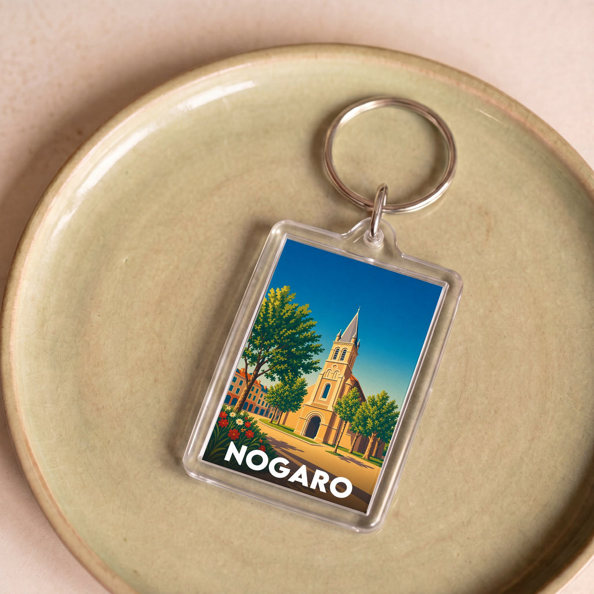 Porte-clés souvenir de la ville de Nogaro avec une illustration stylisée.