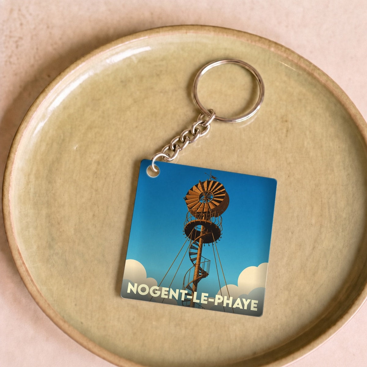 Porte-clés souvenir de la ville de Nogent-le-Phaye avec une illustration stylisée d'une éolienne ancienne.
