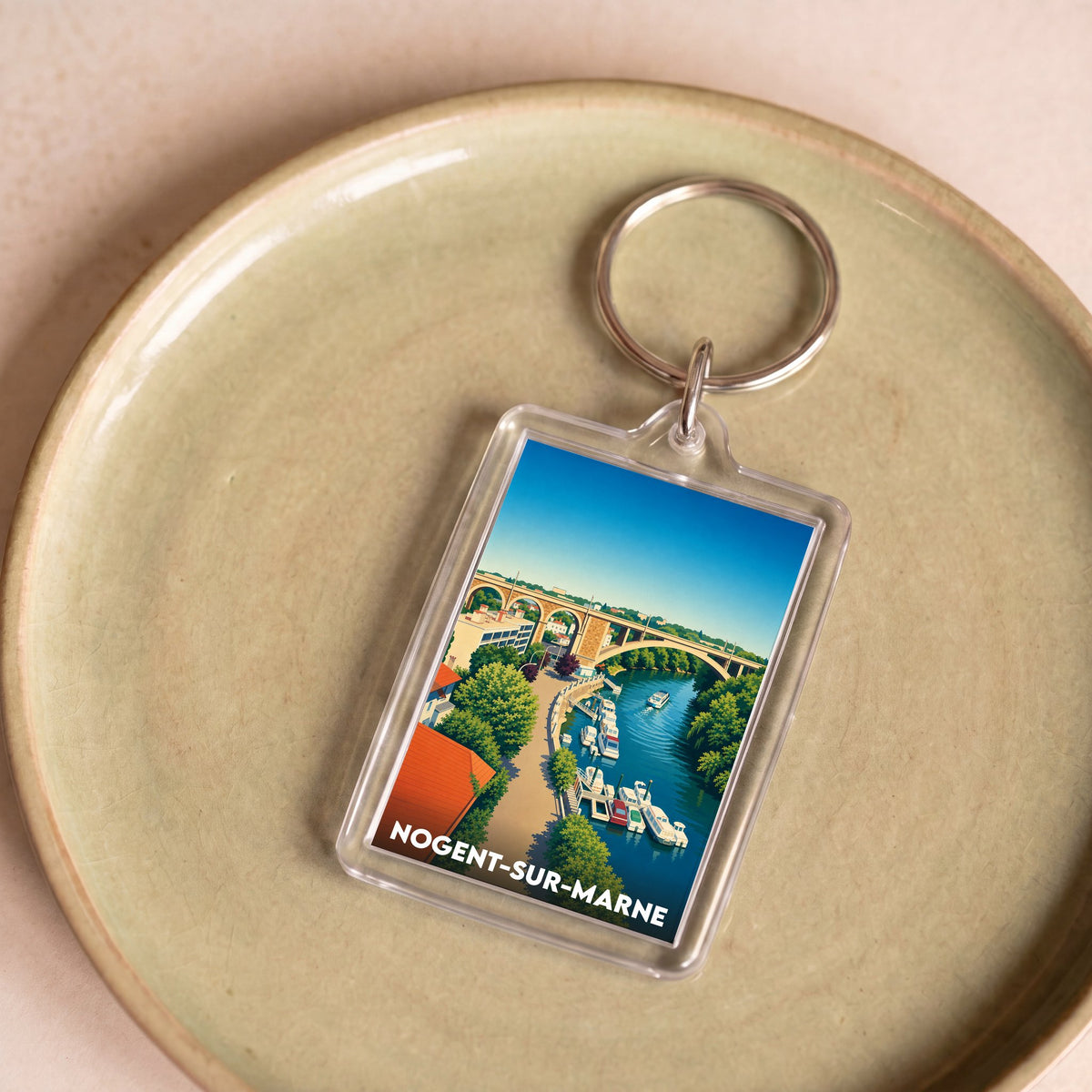 Porte-clés souvenir de la ville de Nogent-sur-Marne avec une illustration stylisée des bords de Marne.