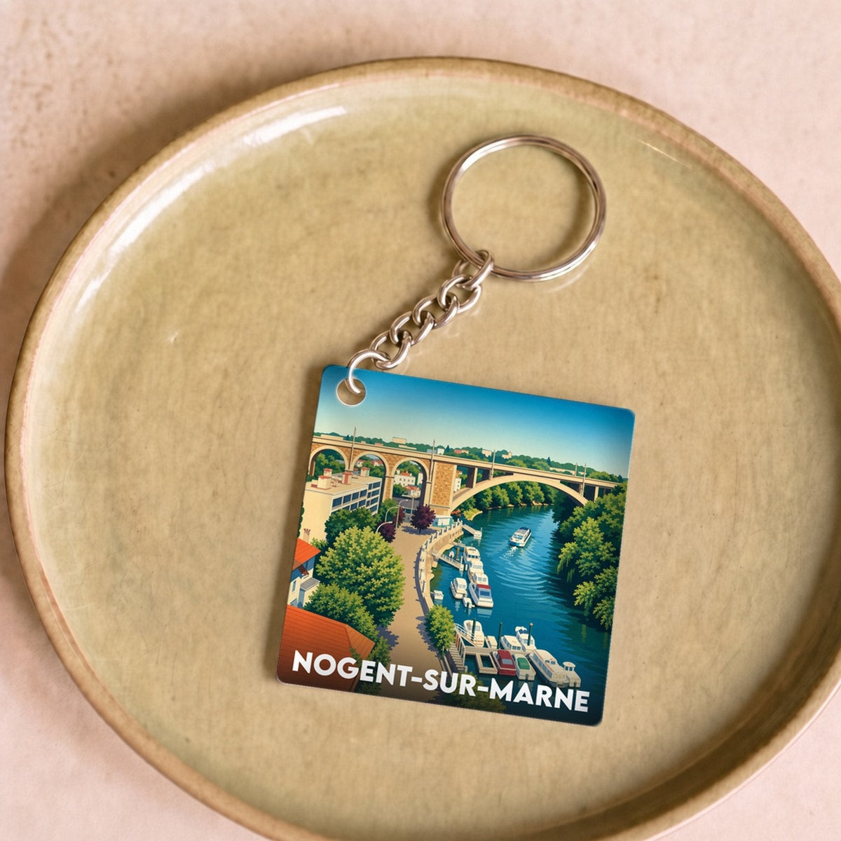 Porte-clés souvenir de la ville de Nogent-sur-Marne avec une illustration stylisée des bords de Marne.
