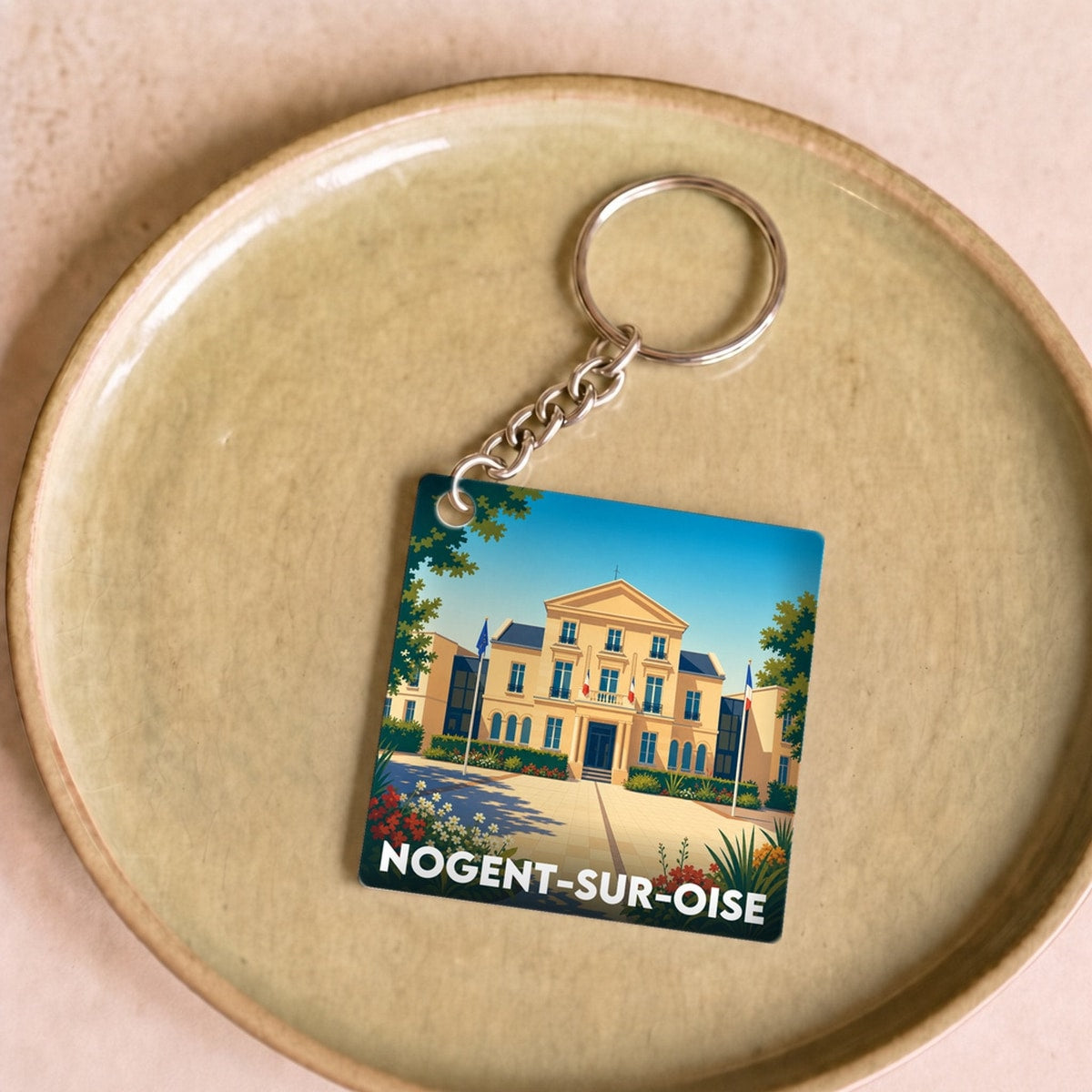 Porte-clés souvenir de la ville de Nogent-sur-Oise avec une illustration stylisée de son hôtel de ville.
