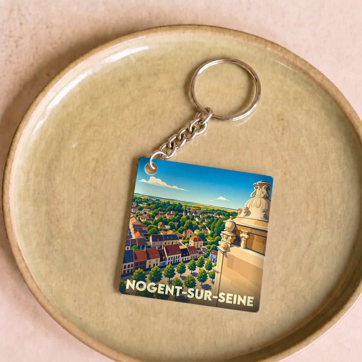 Porte-clés souvenir de la ville de Nogent-sur-Seine avec une illustration stylisée.