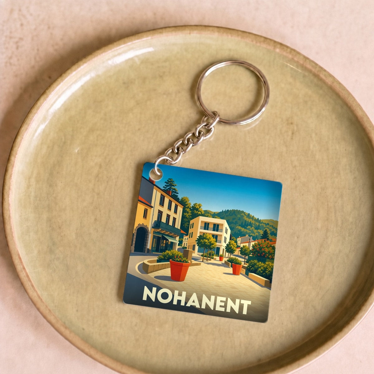 Porte-clés souvenir de la ville de Nohanent avec une illustration stylisée.