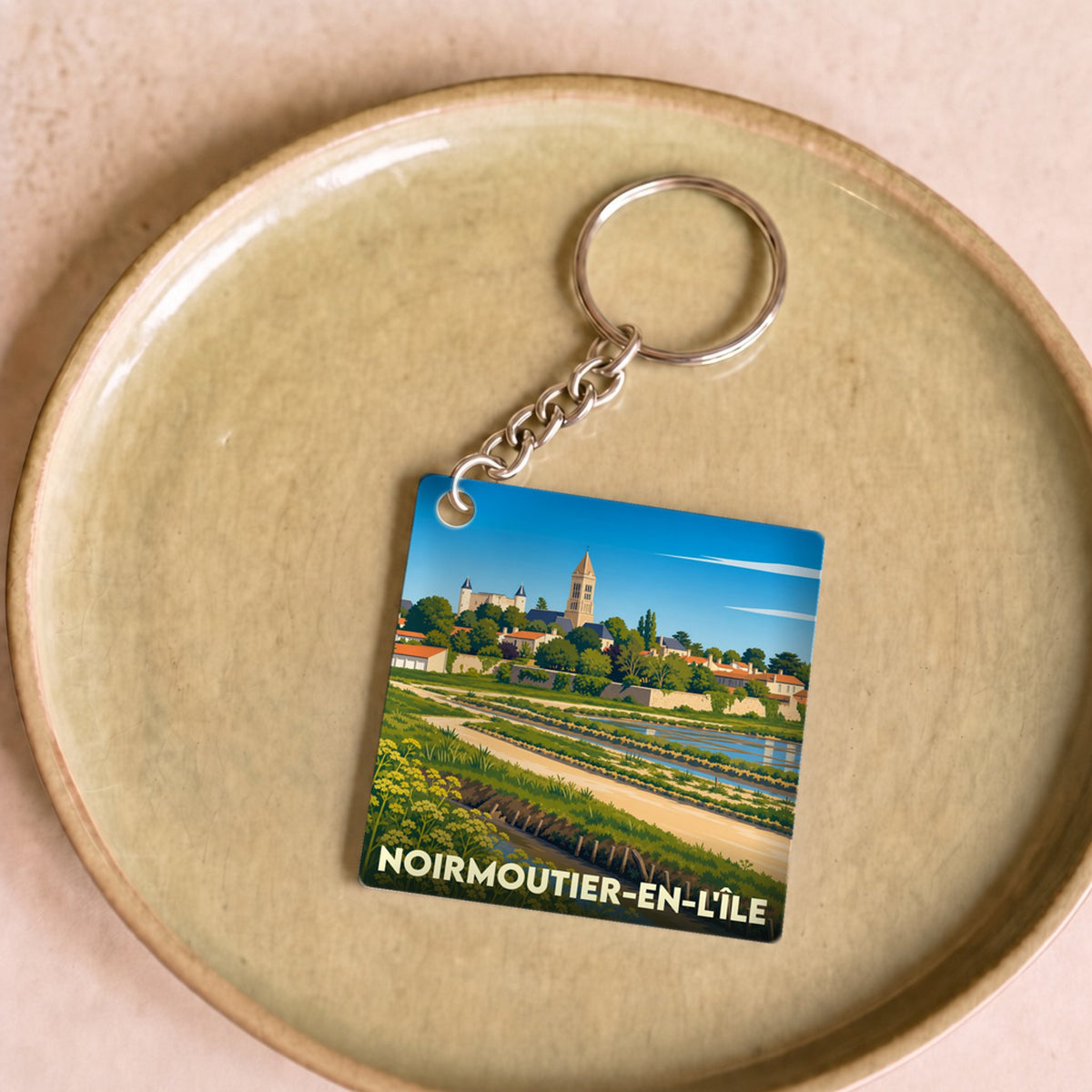 Porte-clés souvenir de Noirmoutier-en-l'Île avec une illustration stylisée des marais salants et du château.