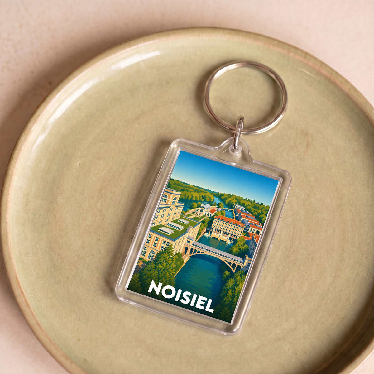 Porte-clés souvenir de la ville de Noisiel avec une illustration stylisée.