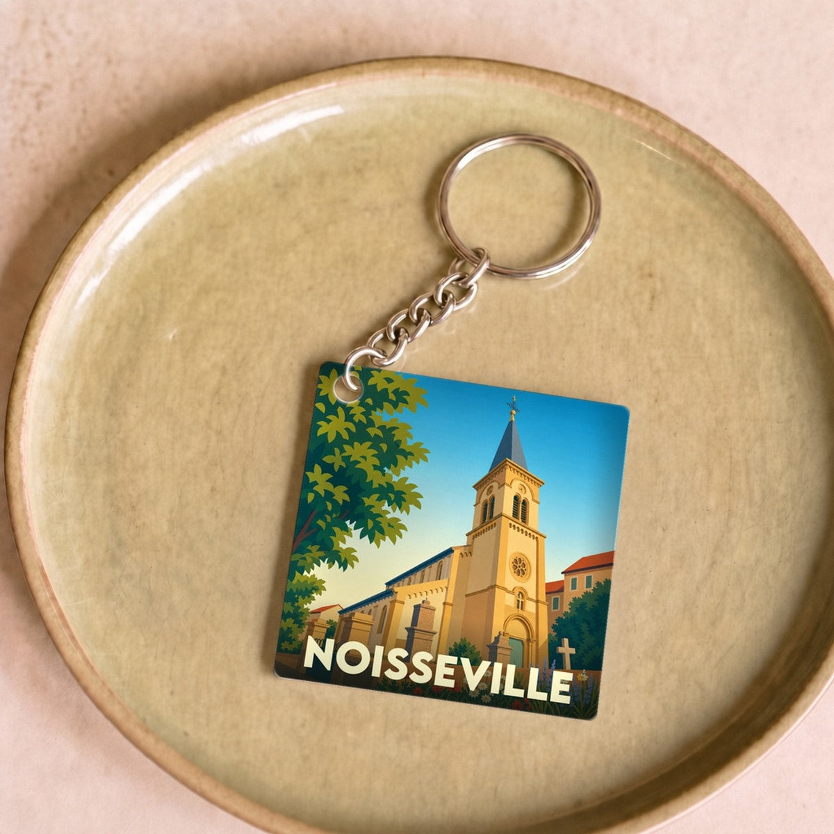 Porte-clés souvenir de la ville de Noisseville avec une illustration stylisée de son église.