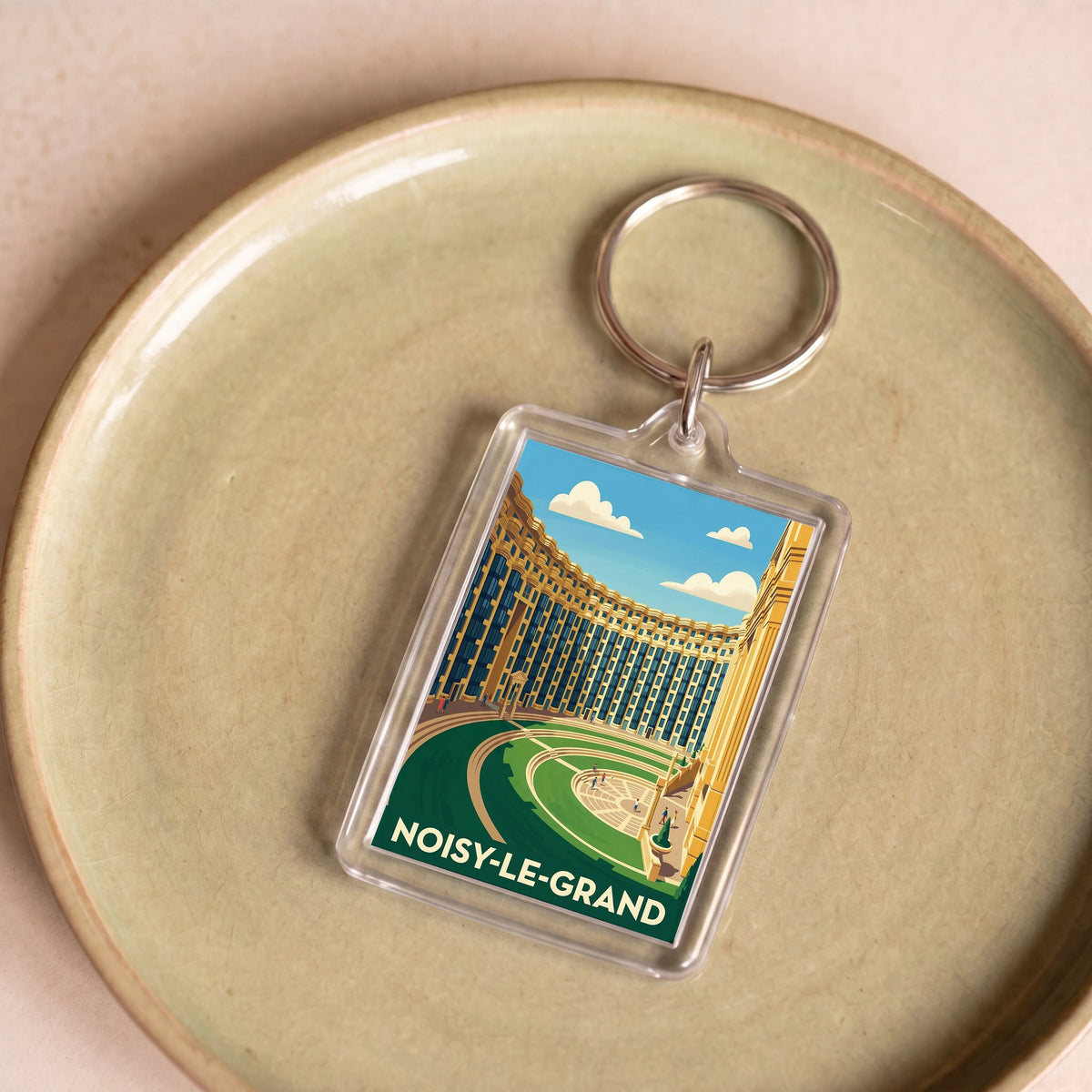 Porte-clés souvenir de la ville de Noisy-le-Grand avec une illustration stylisée.