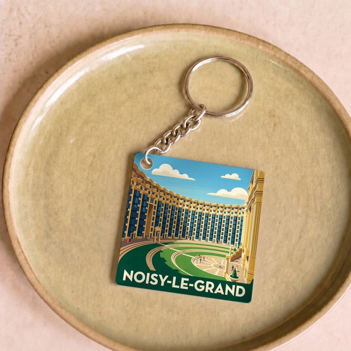 Porte-clés souvenir de la ville de Noisy-le-Grand avec une illustration stylisée.
