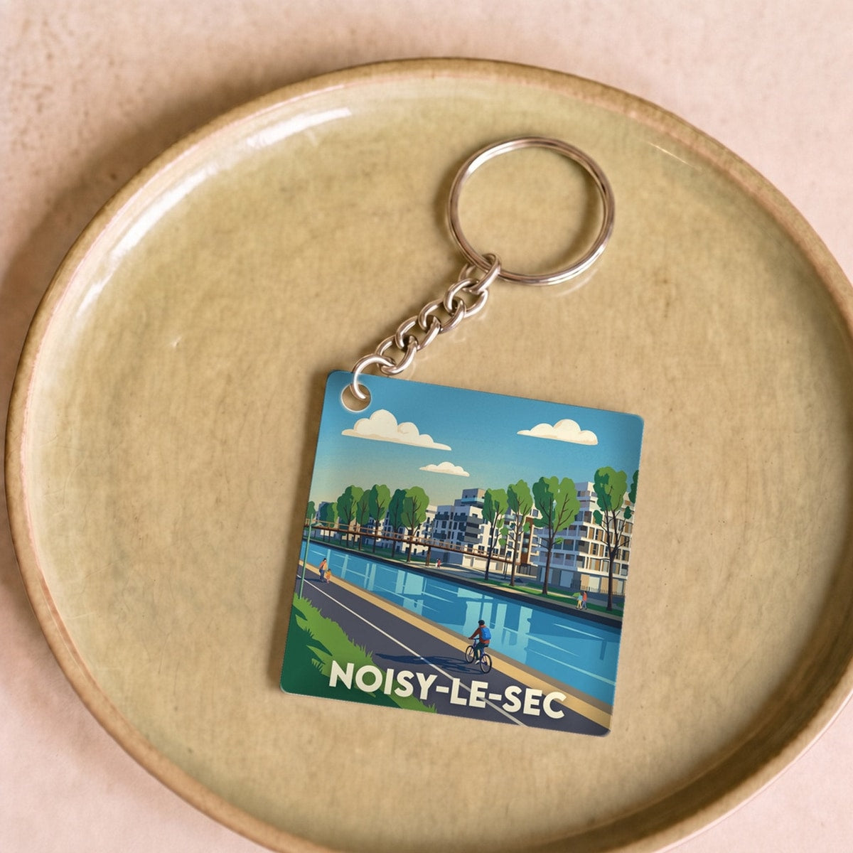 Porte-clés souvenir de la ville de Noisy-le-Sec avec une illustration stylisée.
