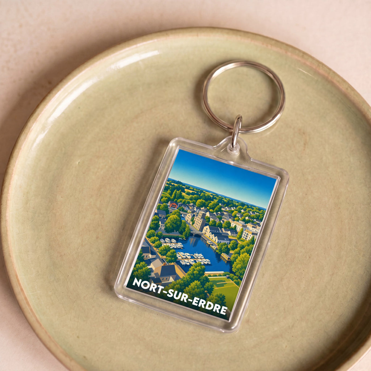 Porte-clés souvenir de la ville de Nort-sur-Erdre avec une illustration stylisée.