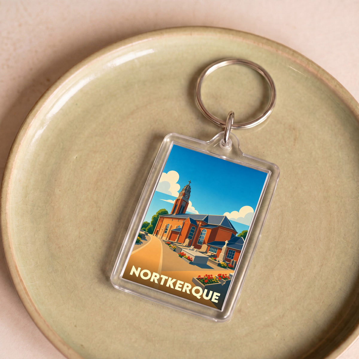Porte-clés souvenir de la ville de Nortkerque avec une illustration stylisée de son église.