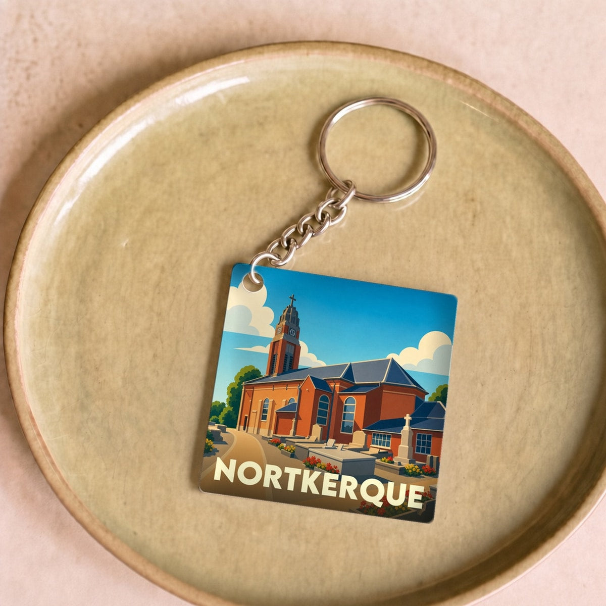 Porte-clés souvenir de la ville de Nortkerque avec une illustration stylisée de son église.